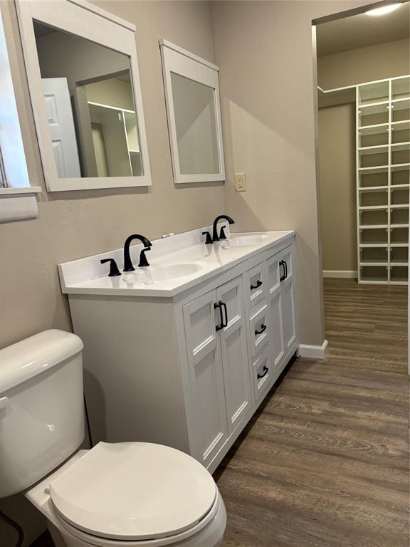 bathroom featuring wood-type flooring, vanity, and toilet