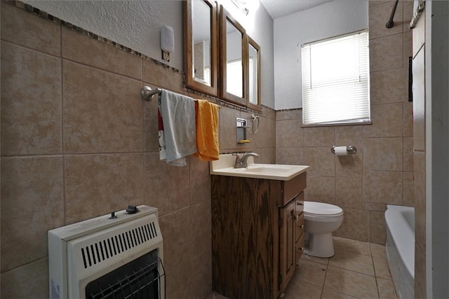 bathroom featuring vanity, tile patterned flooring, toilet, tile walls, and heating unit