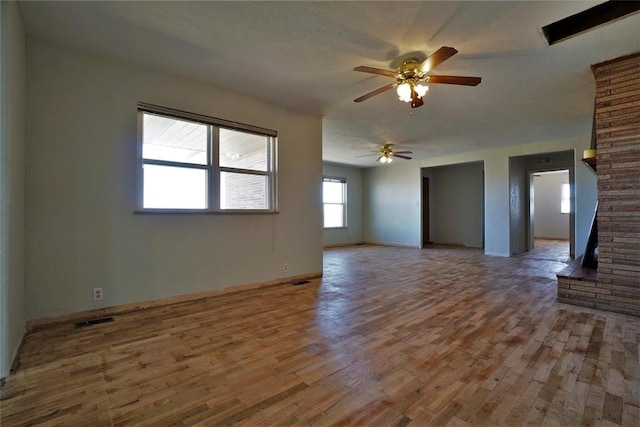 unfurnished living room with wood-type flooring and ceiling fan