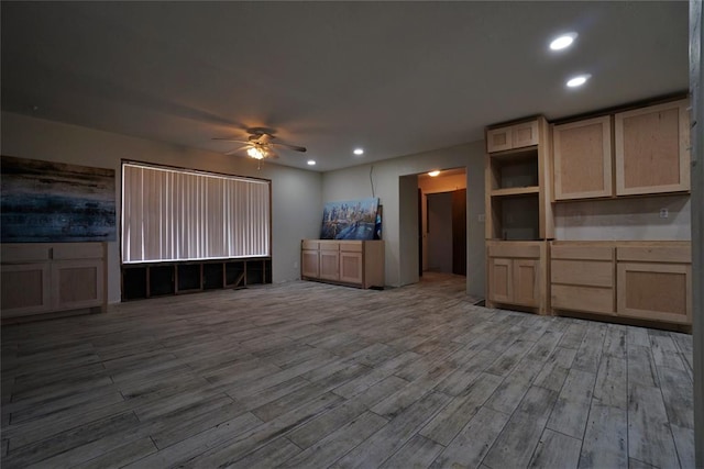 unfurnished living room featuring ceiling fan and hardwood / wood-style floors