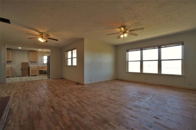 unfurnished living room featuring light hardwood / wood-style floors and ceiling fan