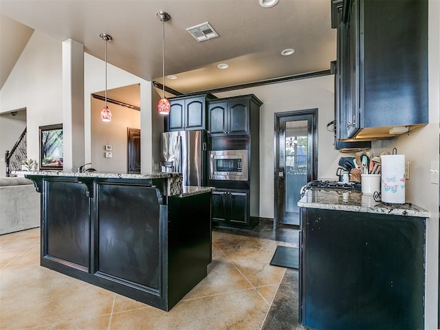 kitchen with light stone counters, stainless steel appliances, and decorative light fixtures