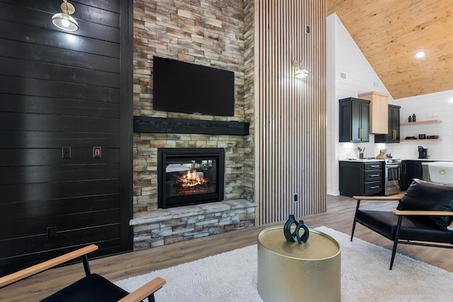 living room with wood ceiling, wooden walls, light hardwood / wood-style flooring, high vaulted ceiling, and a fireplace