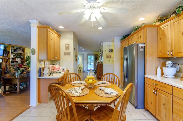 dining area featuring light tile patterned floors, a textured ceiling, and ceiling fan