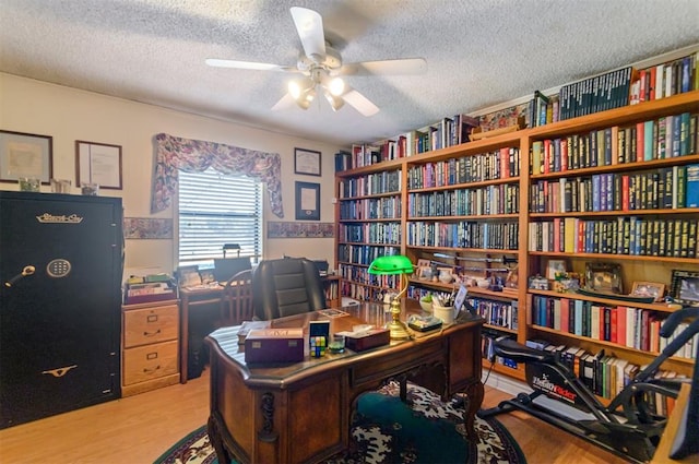 home office featuring ceiling fan, light wood-type flooring, and a textured ceiling