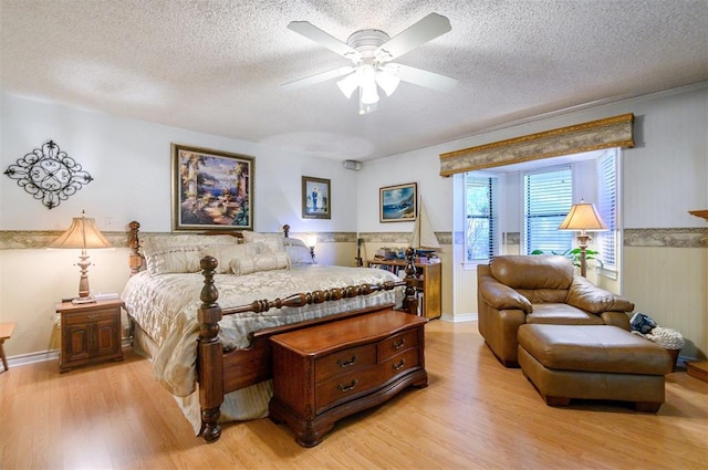 bedroom with ceiling fan, a textured ceiling, and light wood-type flooring