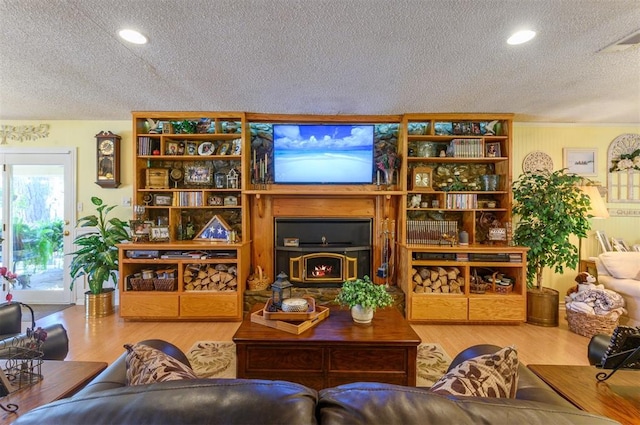 living room featuring wood-type flooring and a textured ceiling