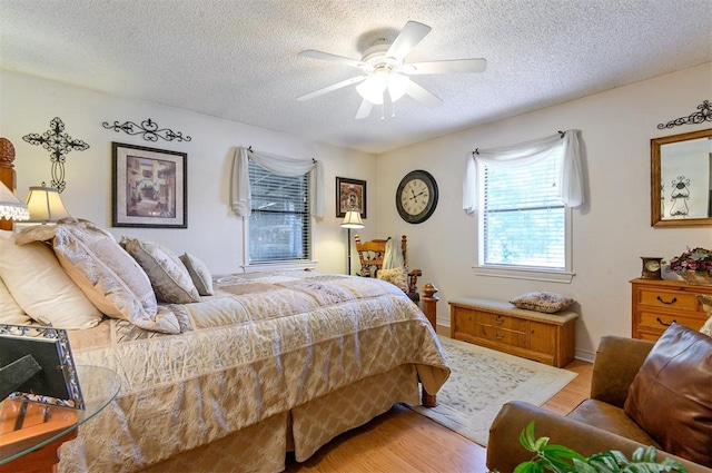 bedroom featuring ceiling fan, a textured ceiling, and light hardwood / wood-style flooring