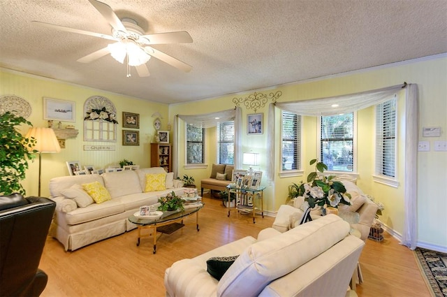 living room with plenty of natural light, light hardwood / wood-style floors, and ceiling fan