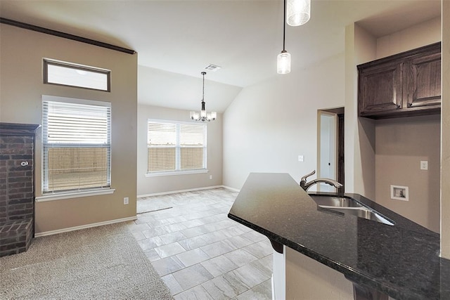 kitchen featuring dark brown cabinetry, sink, a chandelier, hanging light fixtures, and lofted ceiling