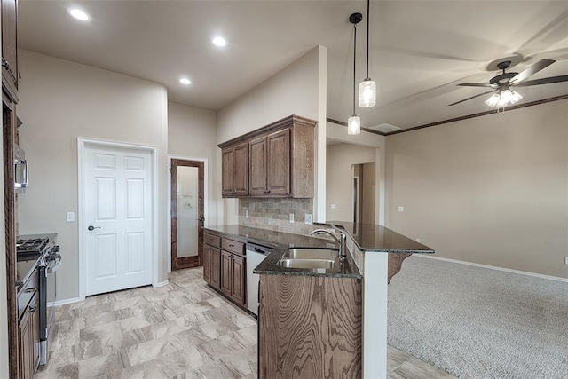 kitchen with ceiling fan, sink, kitchen peninsula, light colored carpet, and appliances with stainless steel finishes