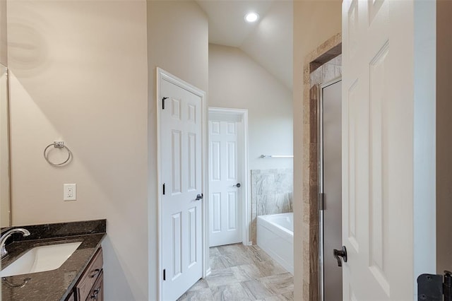 bathroom with vanity, independent shower and bath, and vaulted ceiling