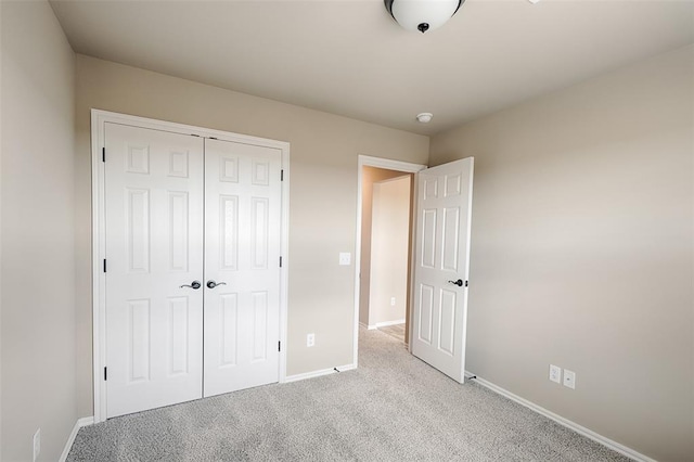 unfurnished bedroom featuring light carpet and a closet