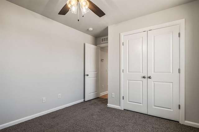 unfurnished bedroom with ceiling fan, a closet, and dark carpet