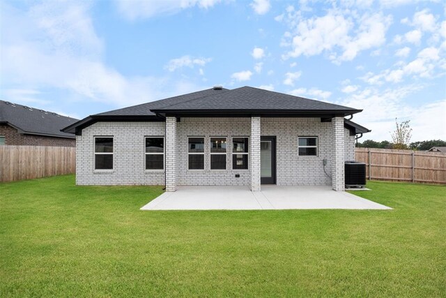 back of property with a lawn, central air condition unit, and a patio