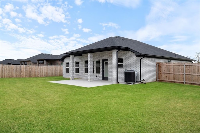 rear view of property featuring a lawn, a patio area, and central air condition unit