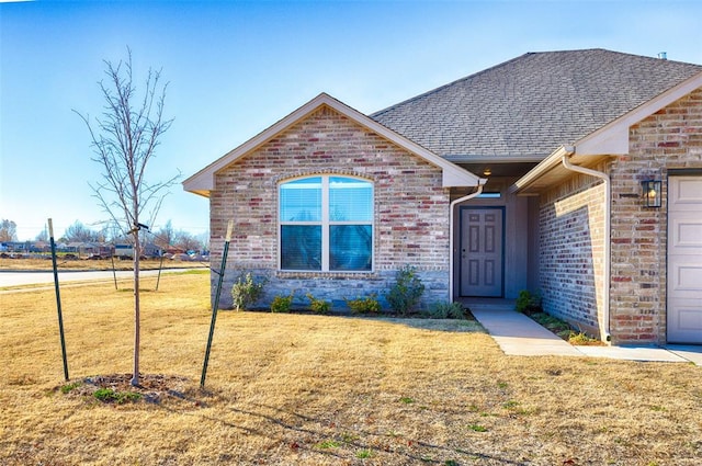 view of front of home featuring a front lawn and a garage