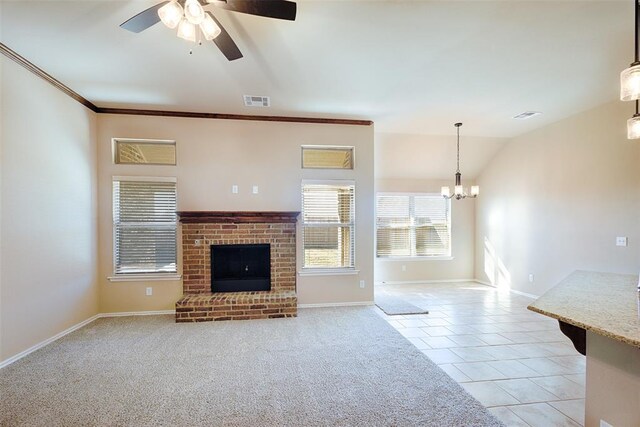 unfurnished living room featuring a brick fireplace, vaulted ceiling, light tile patterned floors, ceiling fan with notable chandelier, and ornamental molding