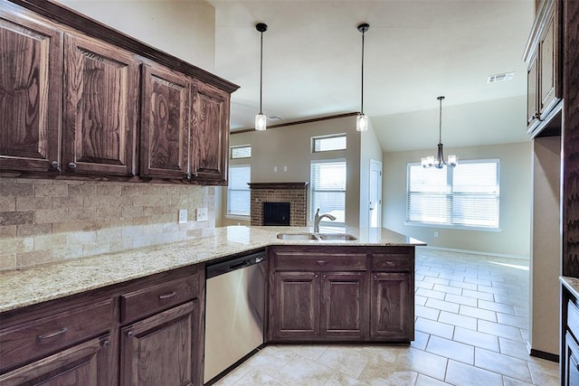 kitchen featuring tasteful backsplash, stainless steel dishwasher, sink, a chandelier, and hanging light fixtures