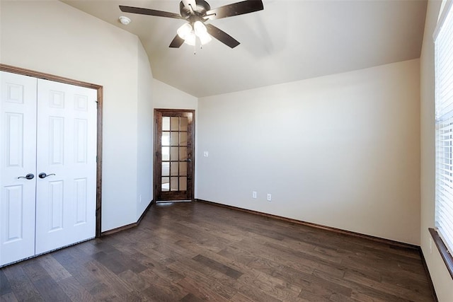 unfurnished bedroom featuring dark hardwood / wood-style floors, lofted ceiling, and multiple windows