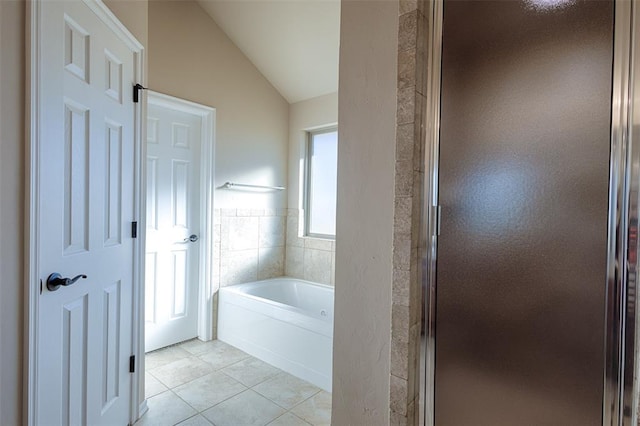 bathroom featuring tile patterned flooring, lofted ceiling, tile walls, and plus walk in shower