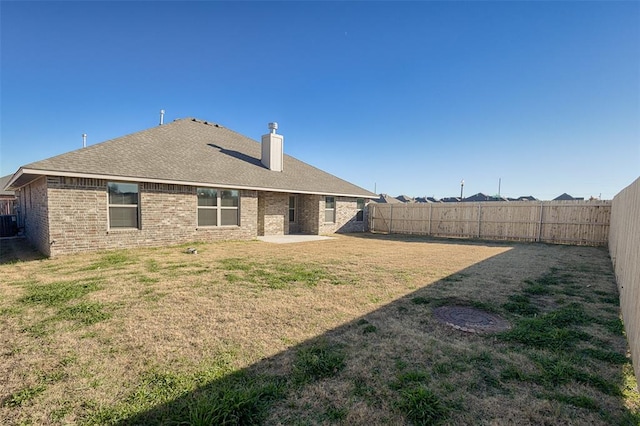 back of house with a patio area and a yard