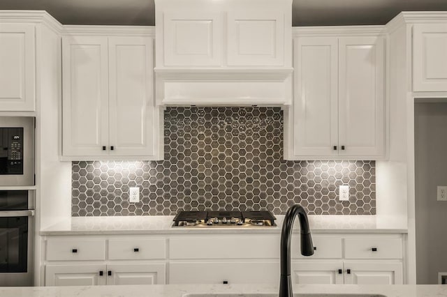 kitchen with white cabinetry, appliances with stainless steel finishes, and tasteful backsplash