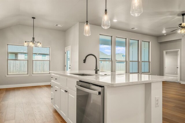 kitchen with stainless steel dishwasher, light wood-type flooring, an island with sink, decorative light fixtures, and white cabinetry