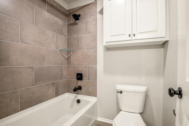 bathroom with toilet and tiled shower / bath