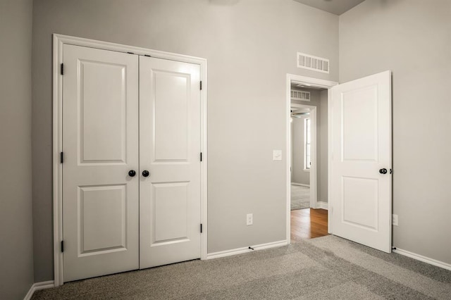 unfurnished bedroom with light carpet and a closet