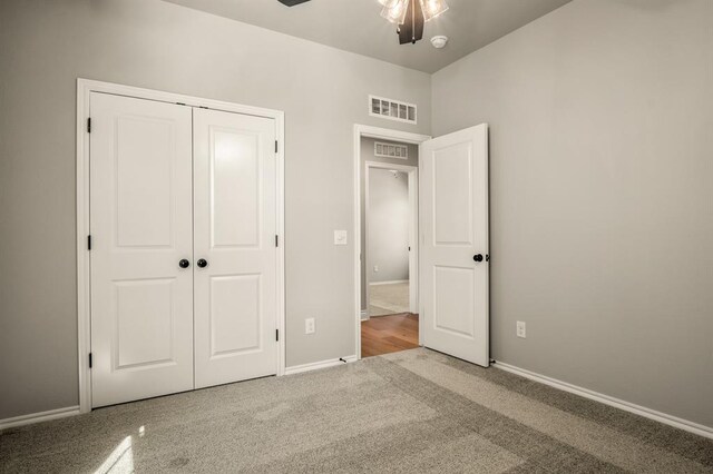 unfurnished bedroom with carpet, a closet, and ceiling fan