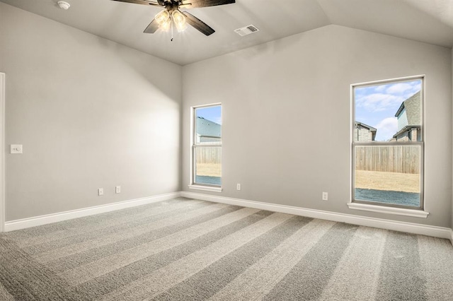 unfurnished room with a wealth of natural light, carpet, and lofted ceiling