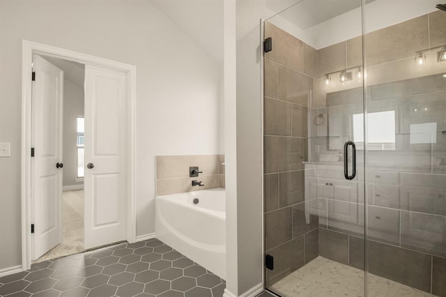 bathroom with tile patterned flooring, independent shower and bath, and lofted ceiling