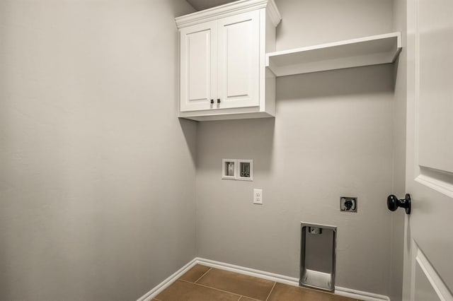 laundry room with cabinets, hookup for a washing machine, dark tile patterned floors, and electric dryer hookup