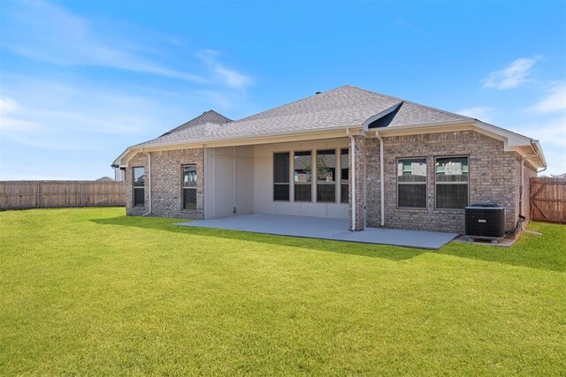 rear view of property featuring a patio area, a yard, and central AC