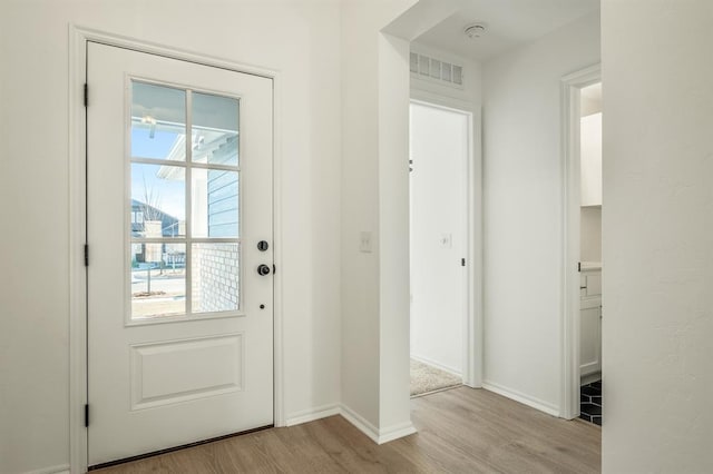 doorway with light hardwood / wood-style floors and a wealth of natural light