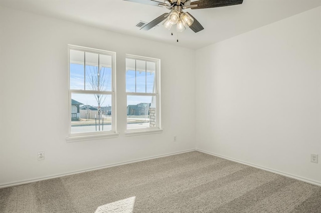 carpeted spare room featuring ceiling fan