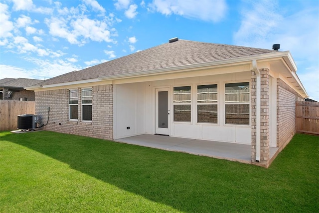 rear view of property with a lawn, a patio, and central AC unit