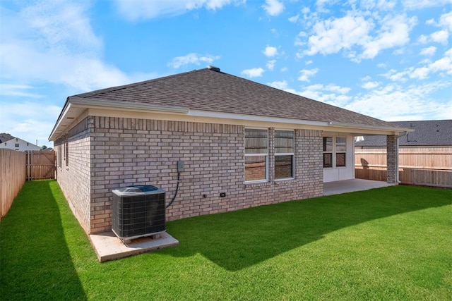 rear view of house with central air condition unit, a yard, and a patio