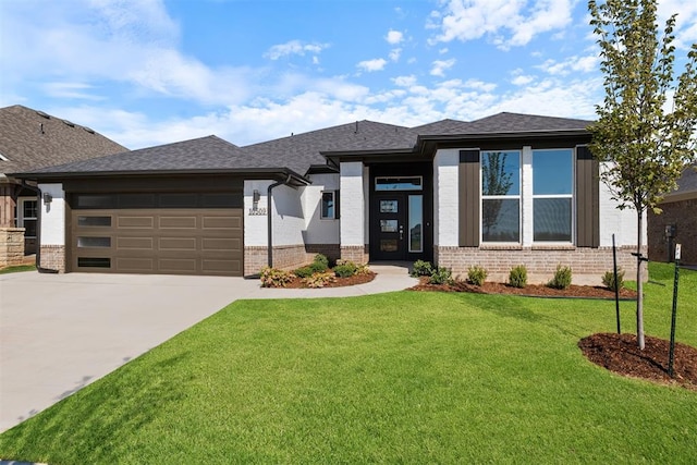 prairie-style home featuring a front yard and a garage