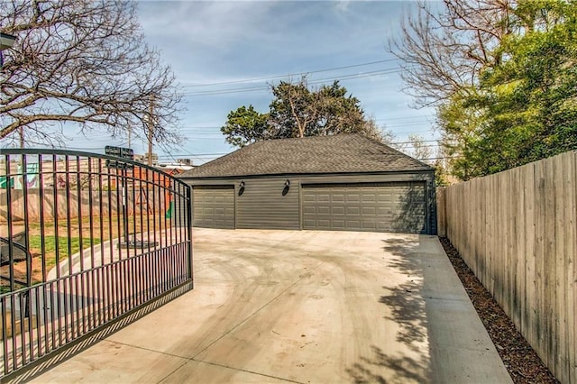 detached garage featuring a gate and fence