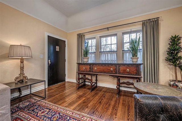 foyer featuring wood finished floors, baseboards, and a textured wall