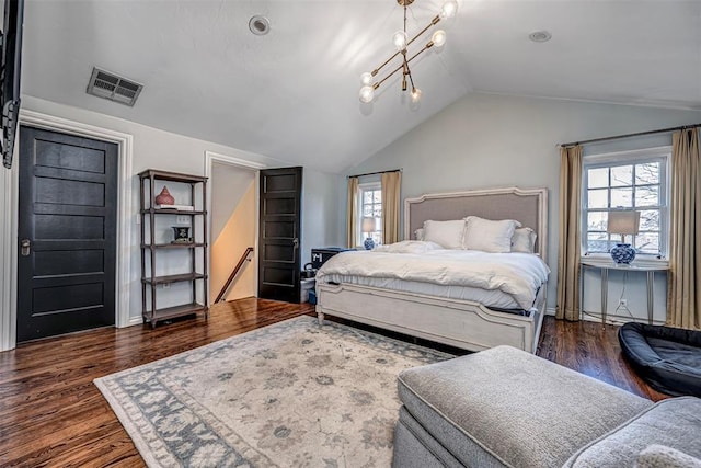 bedroom with visible vents, an inviting chandelier, wood finished floors, and vaulted ceiling