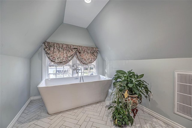 home office featuring baseboards and vaulted ceiling