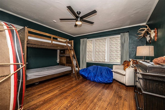 bedroom with ornamental molding, a textured ceiling, ceiling fan, and wood finished floors