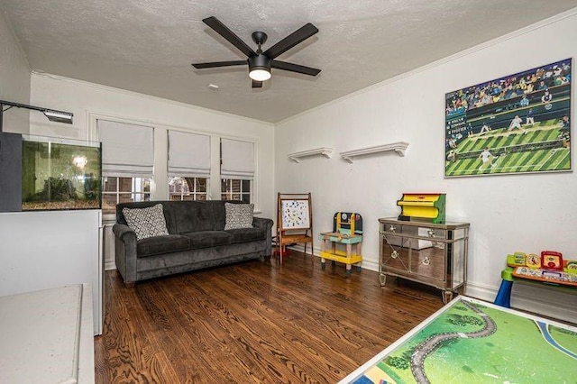 living area with a ceiling fan, ornamental molding, wood finished floors, and a textured ceiling