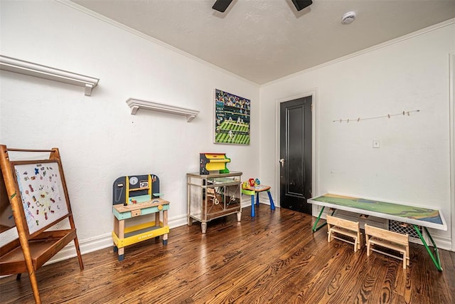 recreation room with baseboards, wood finished floors, and ornamental molding