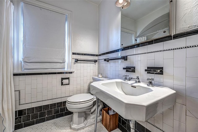 half bathroom with tile patterned floors, toilet, and a sink