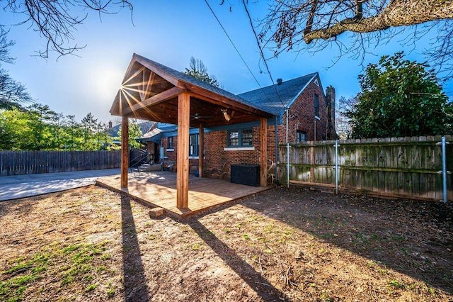 rear view of house featuring brick siding, a patio, and a fenced backyard