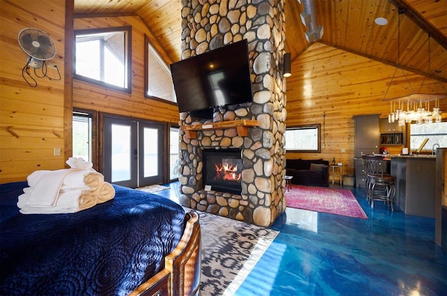 bedroom with wood walls, wood ceiling, a fireplace, and high vaulted ceiling